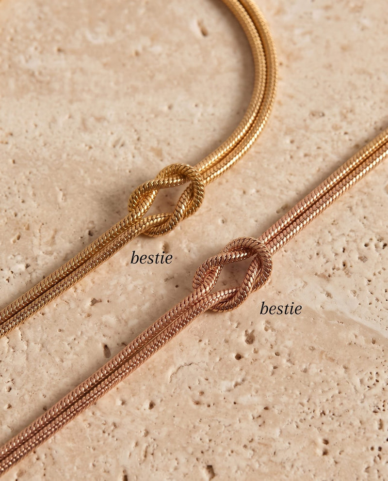 Two matching bestie knot bracelets in gold and rose gold