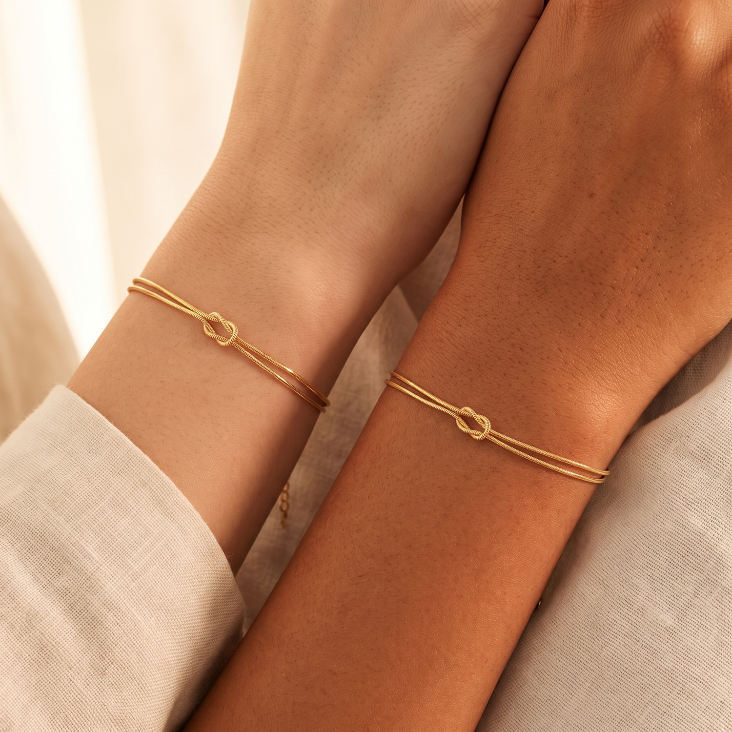 Two friends wearing matching gold eternal bond knot bracelets